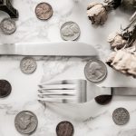high-angle-view-coins-fork-table